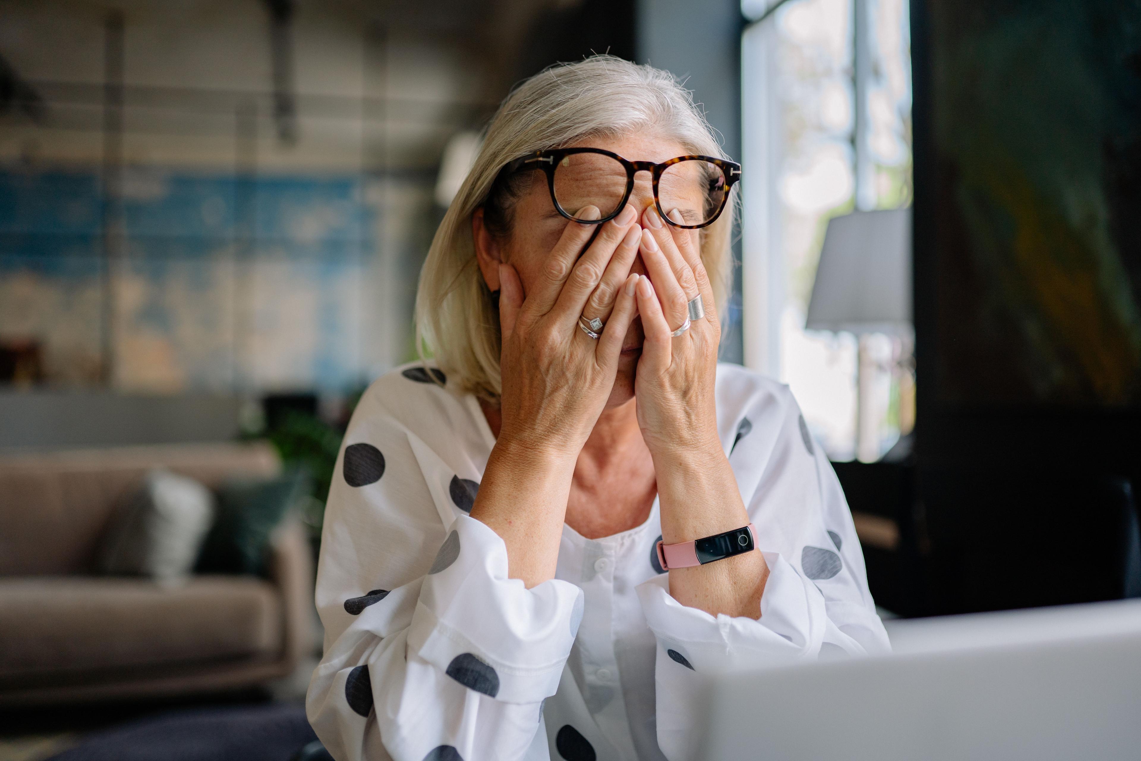 middle aged woman stressfully facepalm