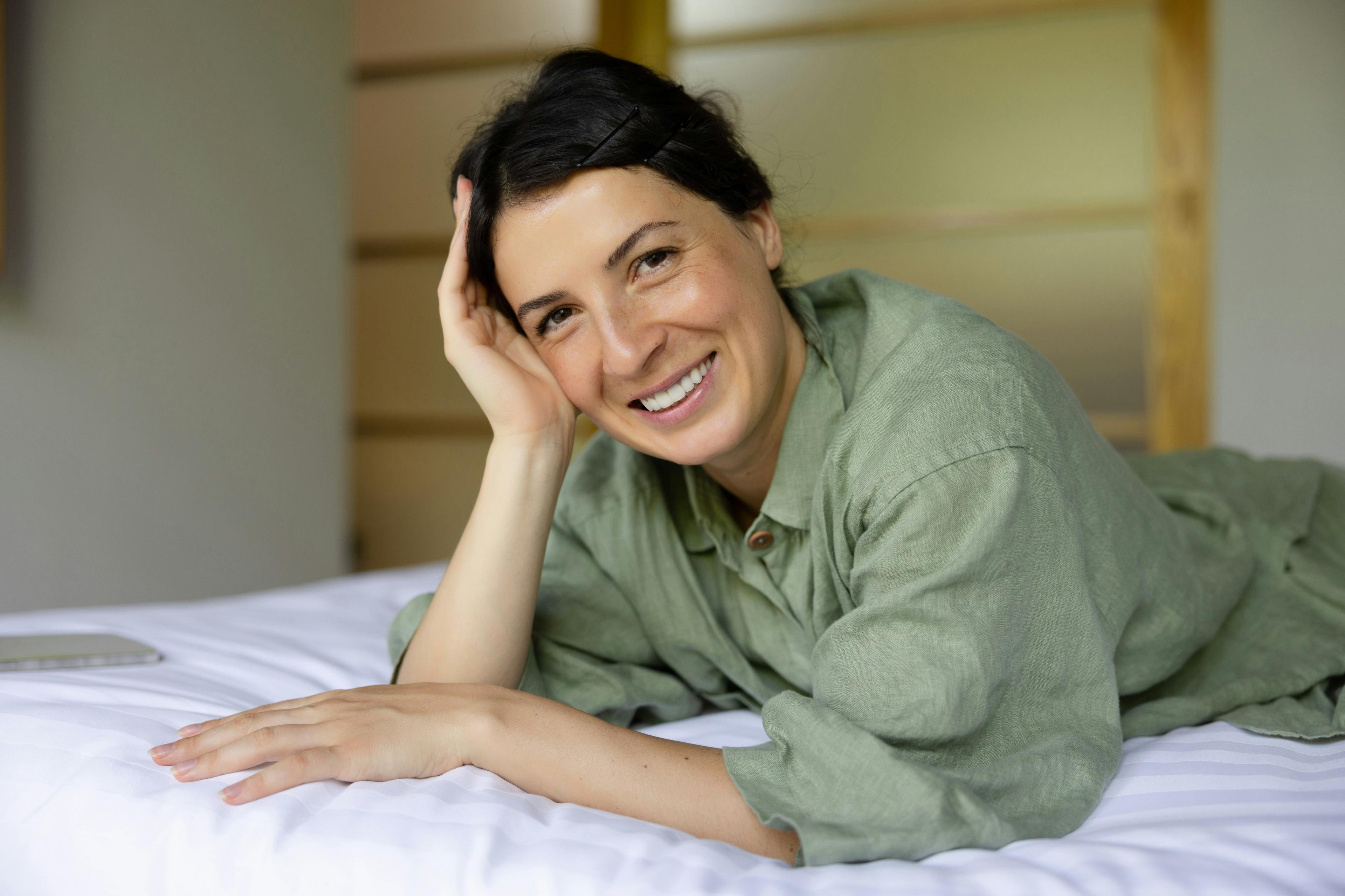 Mature woman lying happily on bed